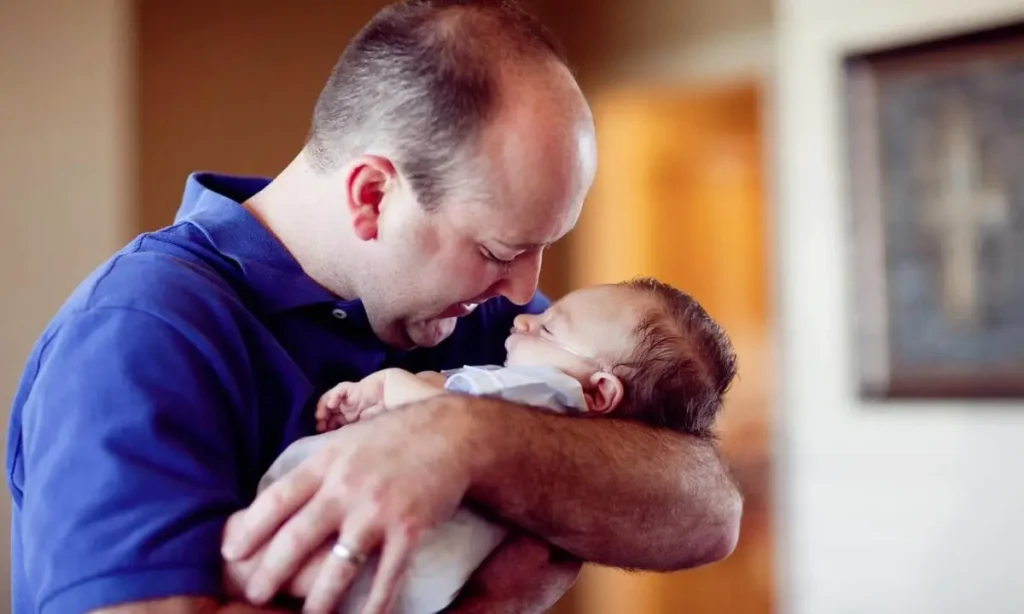 In the picture Patrick Woodruff is cradling a precious newborn baby in his arms